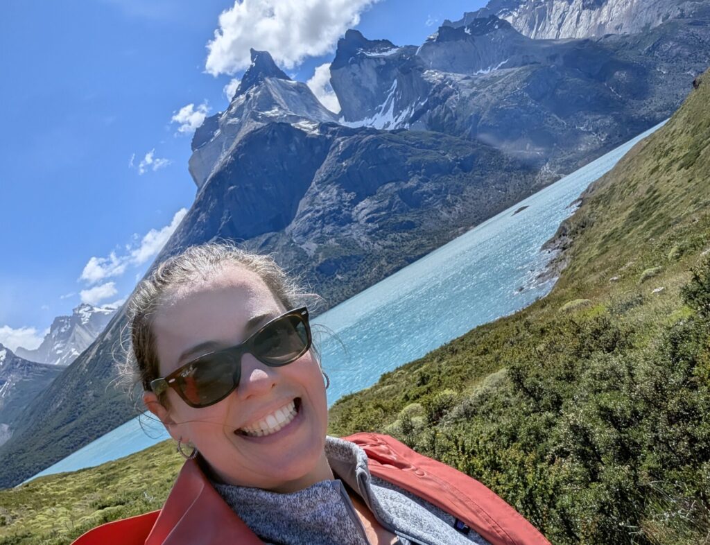 A woman standing in front of a lake and mountain in Torres del Paine national park